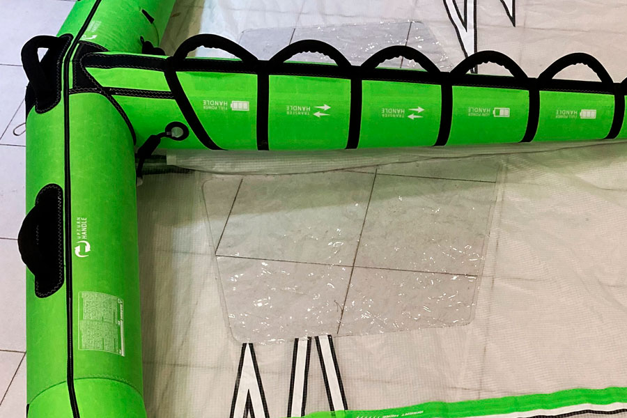 Imagen de un wingfoil hinchado de color verde en proceso de reparación en la tienda Taller Kite de Barcelona